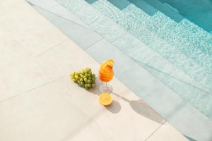 eine Traube, eine Orange und ein Weinglas in der Unterkunft Sunstar Suites in Syvota