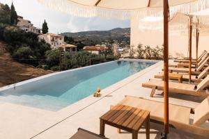 ein Swimmingpool mit Blick auf eine Villa in der Unterkunft Sunstar Suites in Syvota