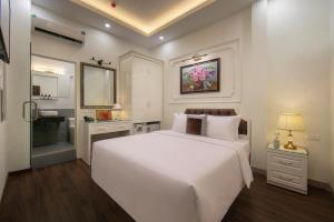a bedroom with a large white bed and a bathroom at Bastra Classy Hotel in Hanoi +80 photos