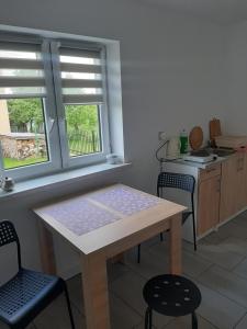 a kitchen with a table and chairs and two windows at Agroturystyka u Pauliny in Sąpów +7 photos