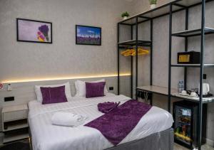 a bedroom with a large bed with purple pillows at Lavanda hotel Tashkent in Tashkent +23 photos