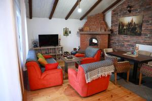 a living room with red chairs and a fireplace at Sokolovic STD in Lapotince