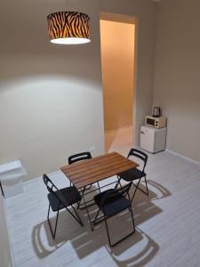 a dining room with a wooden table and four chairs at Zippy Hostel in Milan
