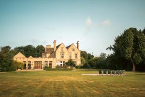 a large house with chairs in front of it at Bagden Hall Hotel in Scissett