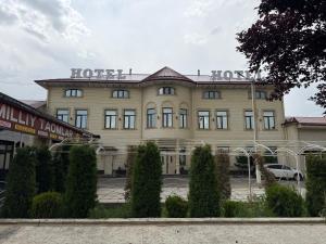 a large building with a sign on top of it at CMC Hotel Apartment in Samarkand