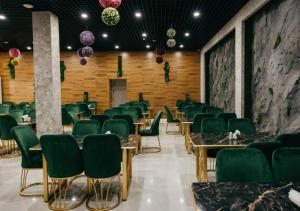 a dining room with green chairs and tables at Lavanda hotel Tashkent in Tashkent