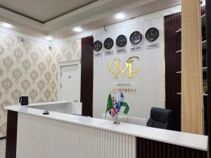 an office with a reception counter and clocks on the wall at CMC Hotel Apartment in Samarkand