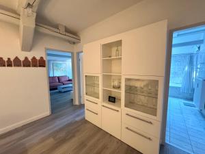 a room with white cabinets and a living room at Brauhaus Suite 19 in Sebnitz