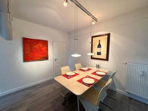 a dining room with a table with chairs and a painting at Brauhaus Suite 19 in Sebnitz