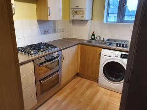 a kitchen with a washing machine and a washer at Double room in a shared 2bed flat in Milton