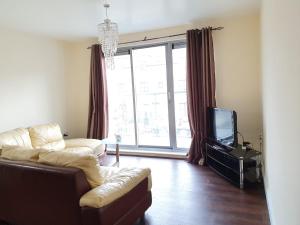 a living room with a couch and a tv at Double room in a shared 2bed flat in Milton