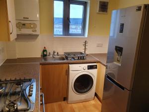 a kitchen with a washing machine and a sink at Double room in a shared 2bed flat in Milton +4 photos