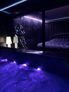 a room with a tub and a bed with purple lighting at Moonlight jacuzzi in Stargard