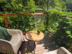 a wooden deck with a table and a chair at Domy w ogrodzie - Riverfront cabins in Poznań