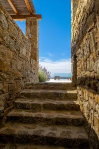 a stone wall with stairs leading to the beach at Nevo Mykonos in Mikonos
