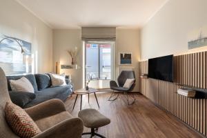 a living room with a couch and a tv at Rodehuus Wohnung 6 in Borkum