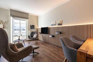 a meeting room with chairs and a table and a television at Rodehuus Wohnung 6 in Borkum