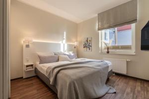 a bedroom with a large bed and a window at Rodehuus Wohnung 6 in Borkum +2 photos