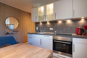 a kitchen with white cabinets and a wooden table at Wittehuus Wohnung 4 in Borkum