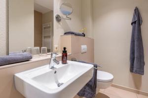 a bathroom with a white sink and a toilet at Wittehuus Wohnung 4 in Borkum +6 photos