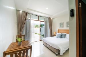 a hotel room with a bed and a balcony at Casa Lucia Resort Hotel in Oslob