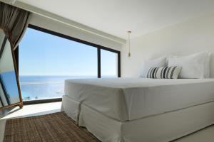a bedroom with a large white bed with a large window at NeRó Villas Lefkada in Tsoukalades +67 photos