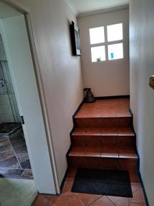 a staircase in a house with a cat sitting on the floor at Durbanville Place - 3 bedroom apartment in Durbanville