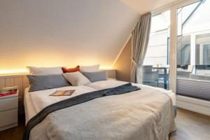 a bedroom with a large bed with a window at Wohnung K13 in Borkum