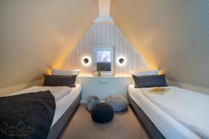 a attic room with two beds and a window at Wohnung K13 in Borkum