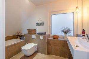 a bathroom with a toilet and a tub and a sink at Wohnung K13 in Borkum