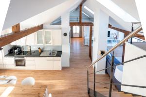 a kitchen with white cabinets and wood floors at Wohnung Strand Vier in Borkum