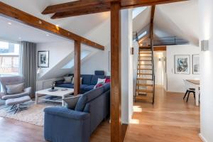 a living room with a blue couch and a staircase at Wohnung Strand Vier in Borkum