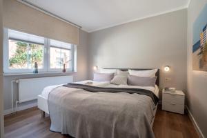 a bedroom with a large bed and two windows at Ferienwohnung Dwarslooper in Borkum