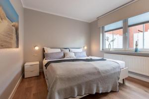 a bedroom with a large bed and a window at Ferienwohnung Dwarslooper in Borkum
