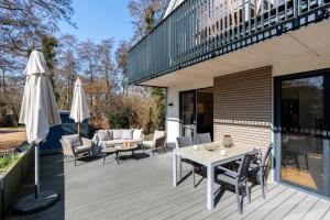 a wooden deck with a table and chairs and an umbrella at Ferienwohnung 1 K20 in Borkum
