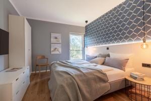 a bedroom with a large bed with a blue wall at Ferienwohnung 1 K20 in Borkum +17 photos