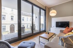 a living room with a couch and a large window at InselLoft Wohnung 1 in Borkum