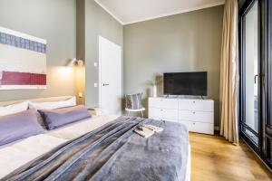 a bedroom with a large bed with a tv on it at InselLoft Wohnung 1 in Borkum +13 photos