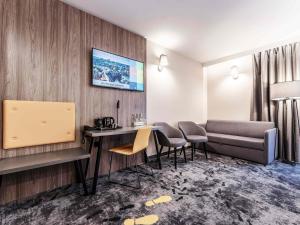 a hotel room with a couch and a table and chairs at ibis Styles Lublin Stare Miasto in Lublin