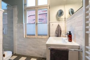 a bathroom with a sink and a toilet and a window at Commandeur-Huus Wohnung 2 in Borkum