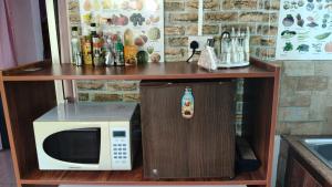 a microwave on a shelf next to a counter at Creole Cottage Homestay in Mahe