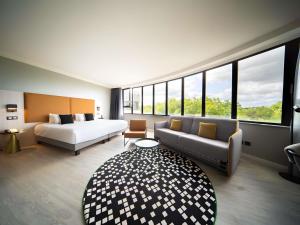 a hotel room with a bed and a couch at Maek Hotel Antwerp Central - Accor Handwritten Collection in Antwerp