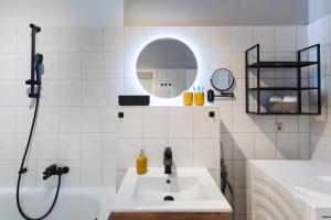 a bathroom with a sink and a shower with a mirror at Altstadt Suite in Freiberg +25 photos