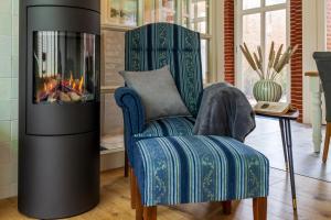 a living room with a chair and a fireplace at Commandeur-Huus Wohnung 1 in Borkum +8 photos