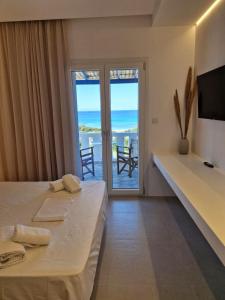 a bedroom with a bed and a view of the ocean at Villa Maniati Chrissi Ammos in Agios Petros +122 photos