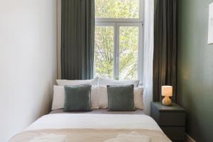 a bedroom with a bed with pillows and a window at Altstadt Suite in Freiberg