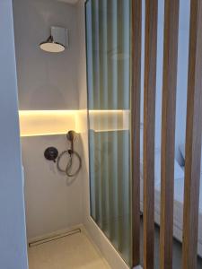 a shower with a glass door next to a bed at Villa Maniati Chrissi Ammos in Agios Petros