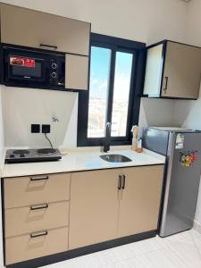 a small kitchen with a sink and a refrigerator at شقة أنيقة جديده في قلب أبها in Abha