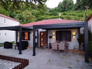 a patio with a black pergola in front of a house at Summer House by the Sea in Chorefto