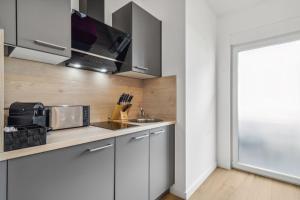 a kitchen with a sink and a microwave at Serviced Apartments Dietzenbach in Dietzenbach